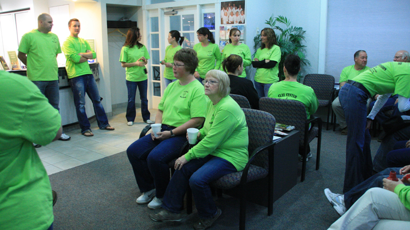 Dental team in bright green t-shirts gathered in the lobby before the start of Clay Center Family Dental Care Dental Mission day