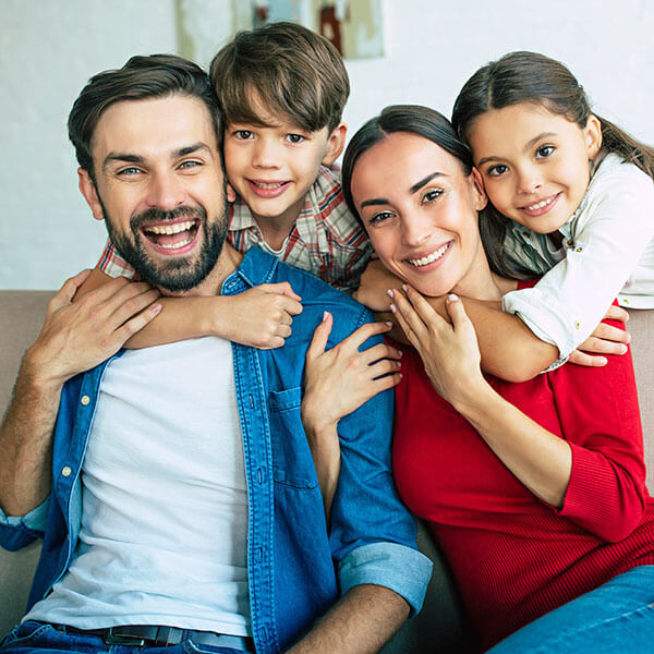 mother and father smiling together with son and daughter