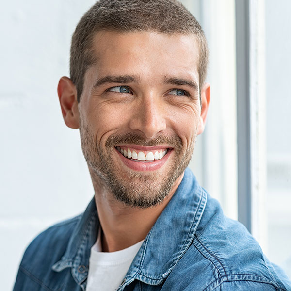 man smiling and looking towards window