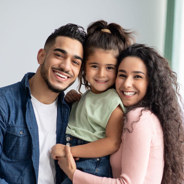 mother and father smiling together with daughter