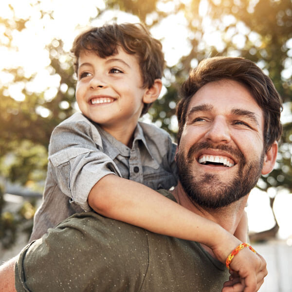 father and son smiling outdoors