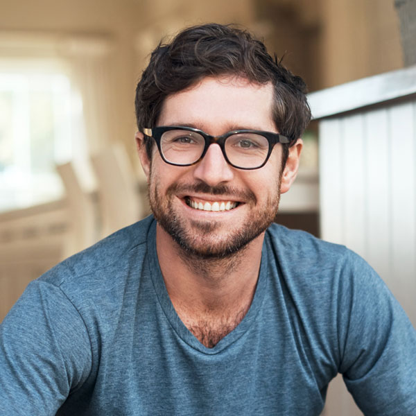 man with glasses smiling at home